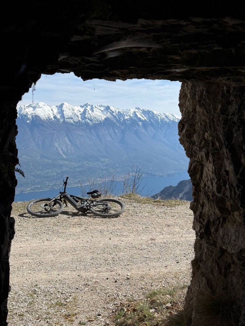 Bike inside WWI rock-cut chamber framing Monte Baldo